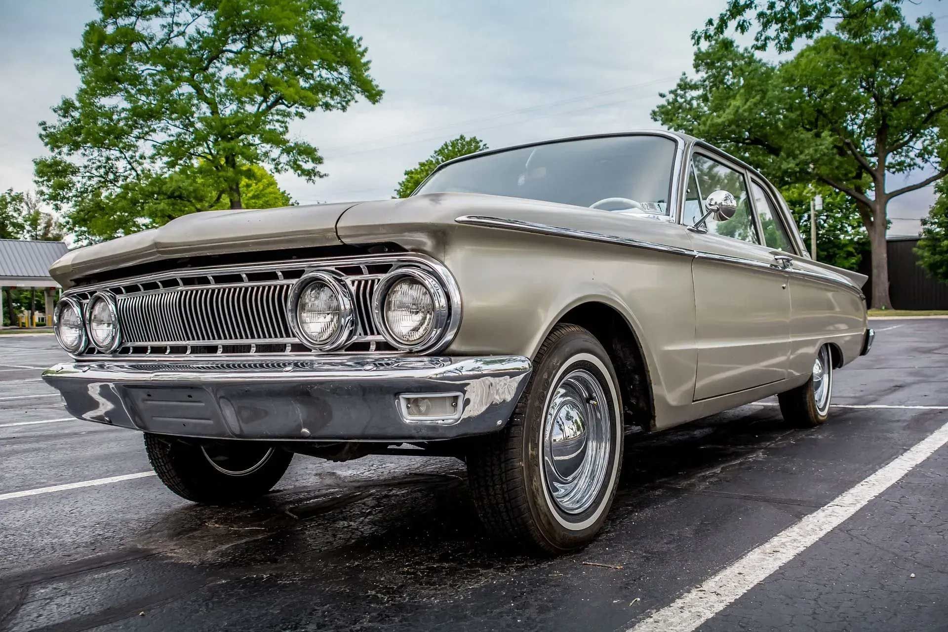 Silver 1963 Mercury Comet car parked in a lot; overcast day.