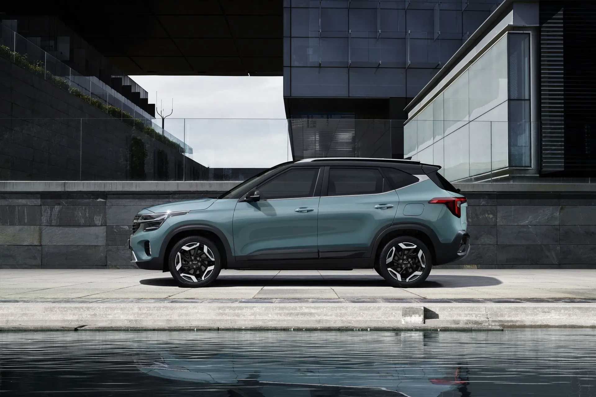 Blue Kia Seltos SUV parked by a building with modern architecture.