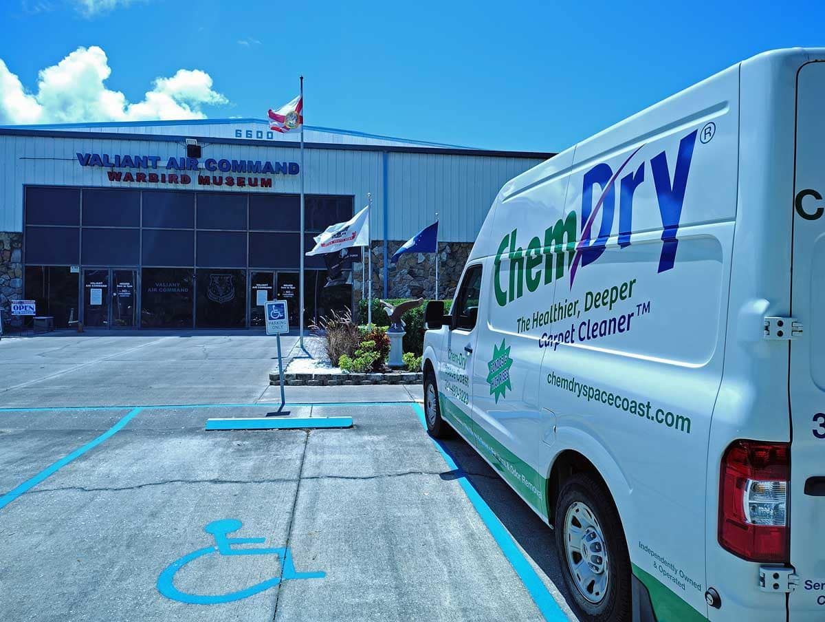Dry cleaning van parked outside a storefront with blue handicap parking spaces in front