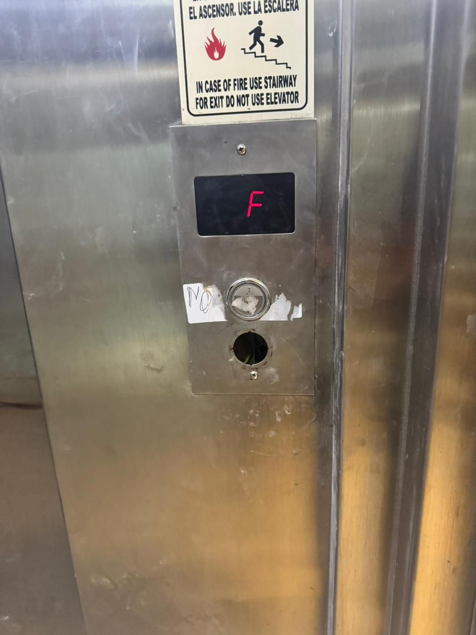 Panel de ascensor de acero inoxidable con indicador de piso que muestra la letra 