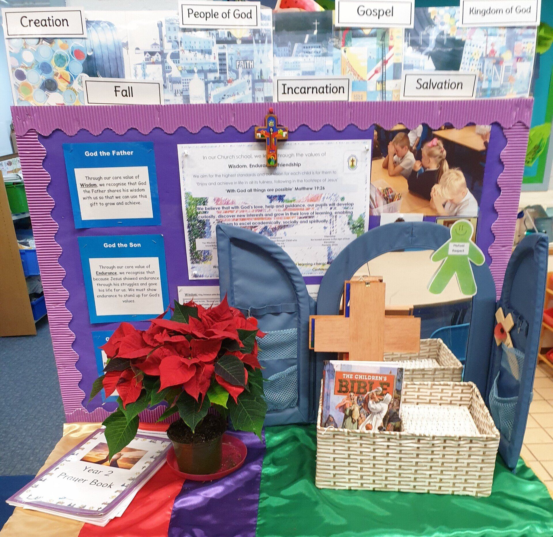 A religious display with bulletin boards, crosses, and potted poinsettia.
