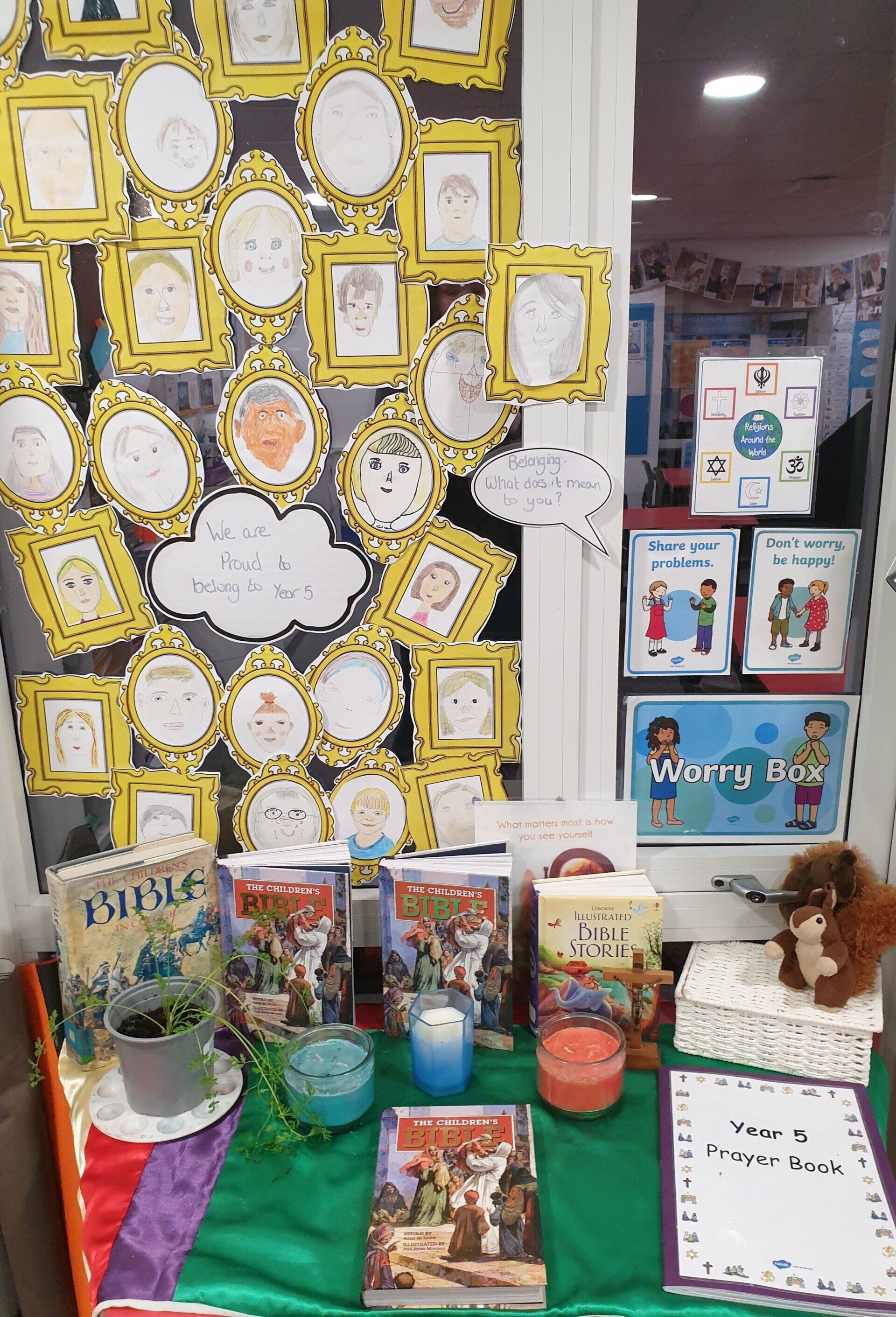 Display of artwork and books; portraits in frames, candles, and a toy bear on a shelf.