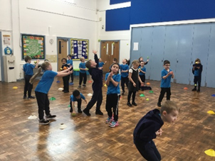 A group of children are doing exercises in a gym.