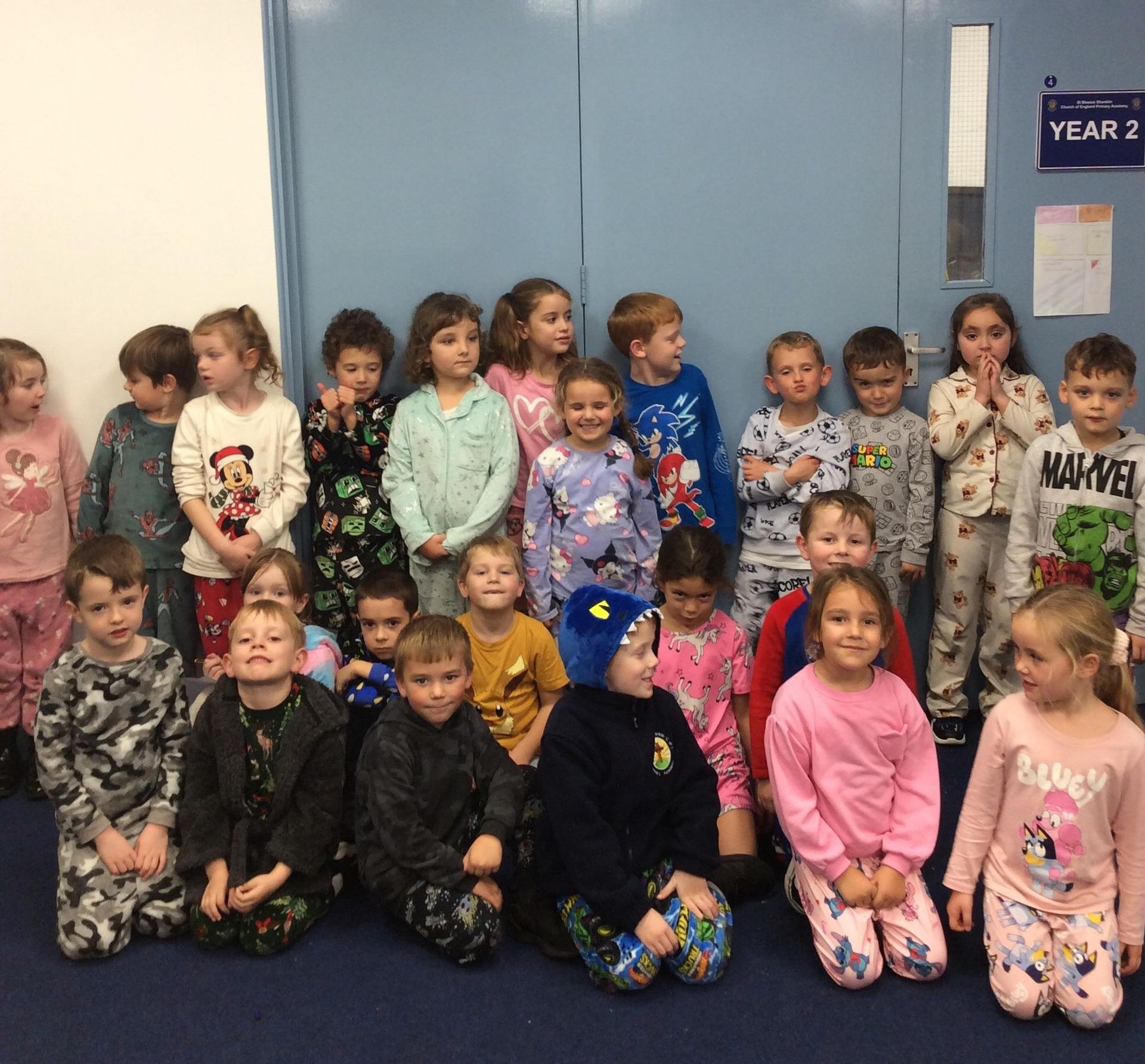 Children in pajamas pose in a classroom; a