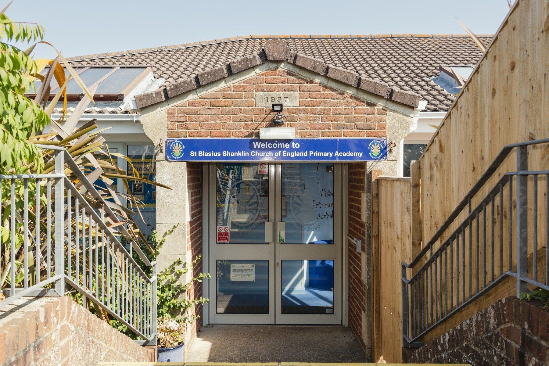 Entrance to St. John's School, Paignton, Devon, UK, with steps leading to the door under a brick gable.
