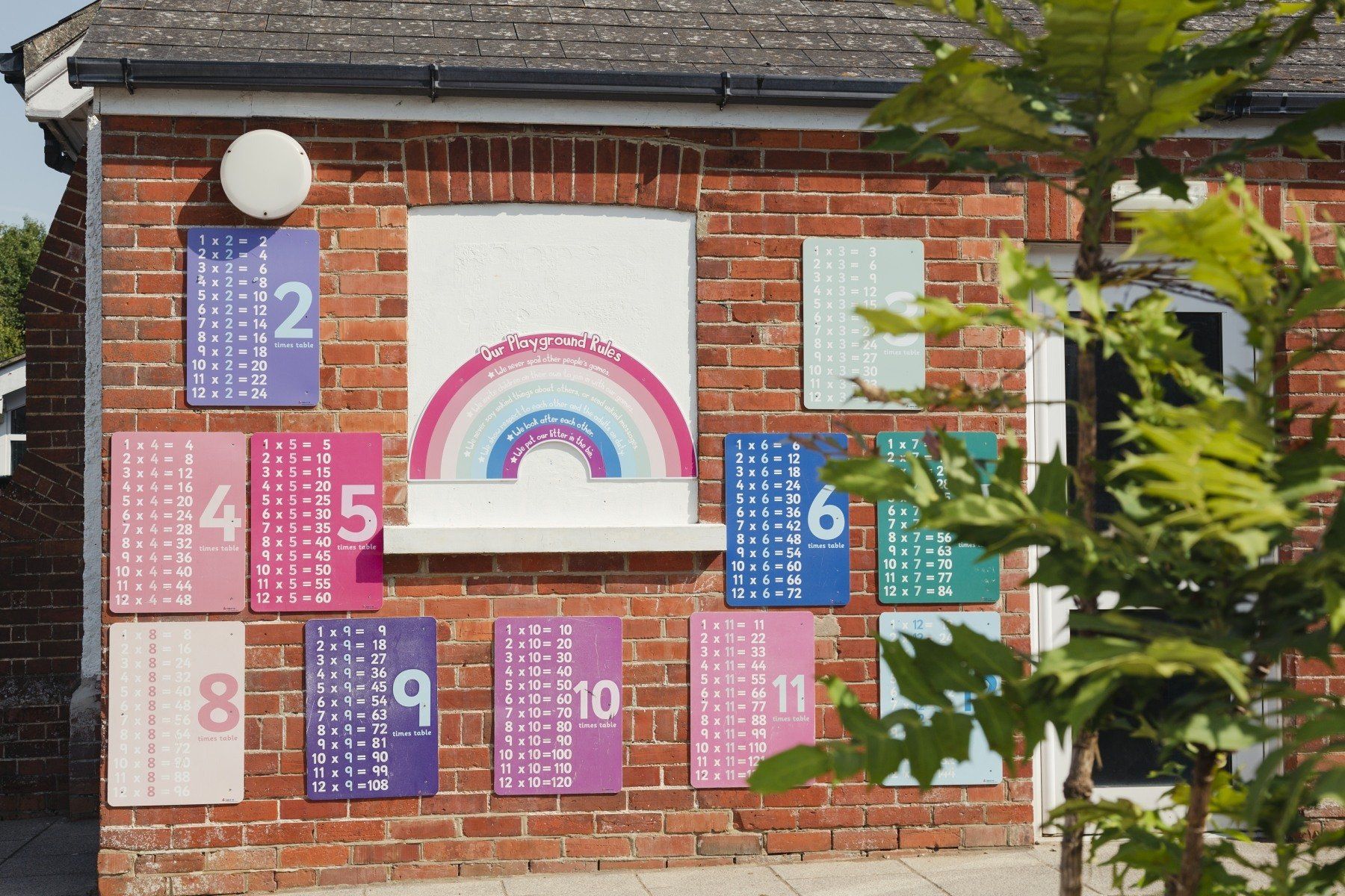 Exterior brick building with colorful educational displays, including numbers and a rainbow.