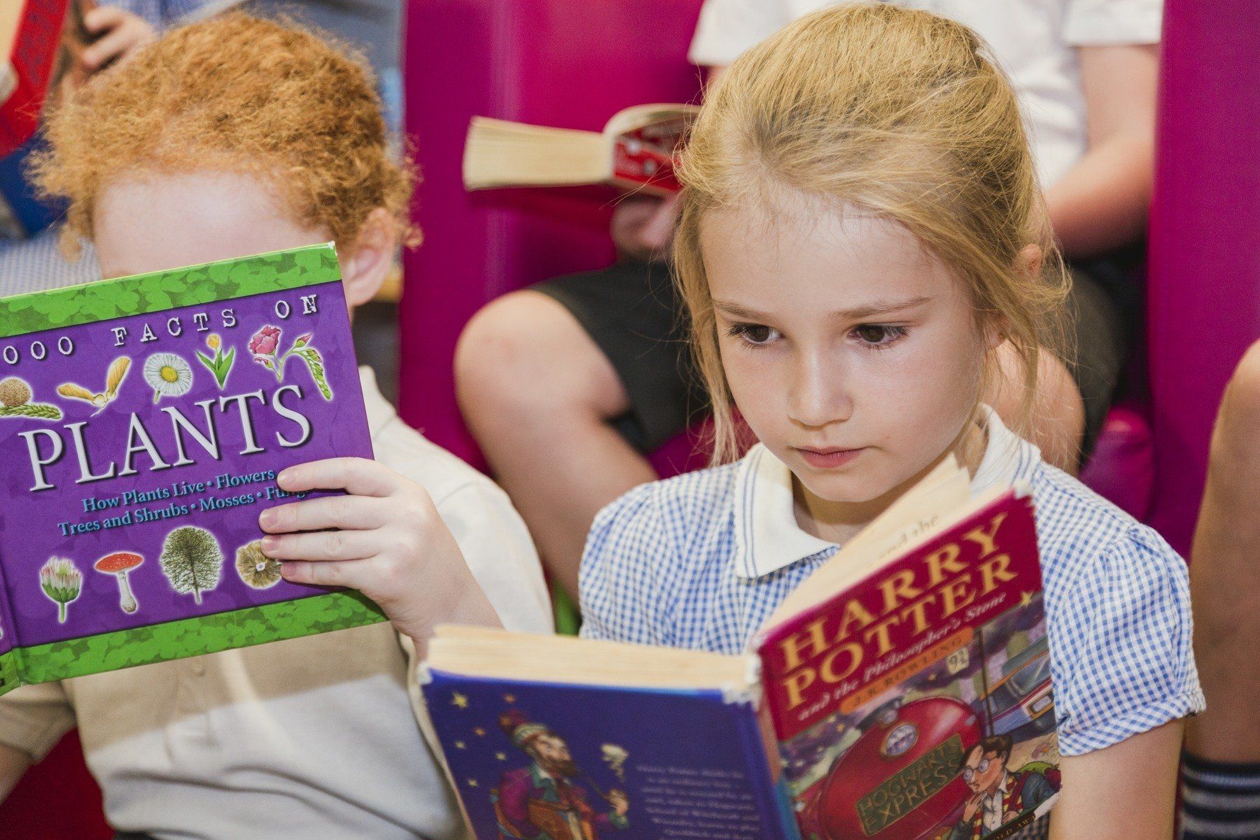 Two children reading books: one