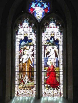 Stained glass windows depict an angel and a figure holding a child, set in a church.