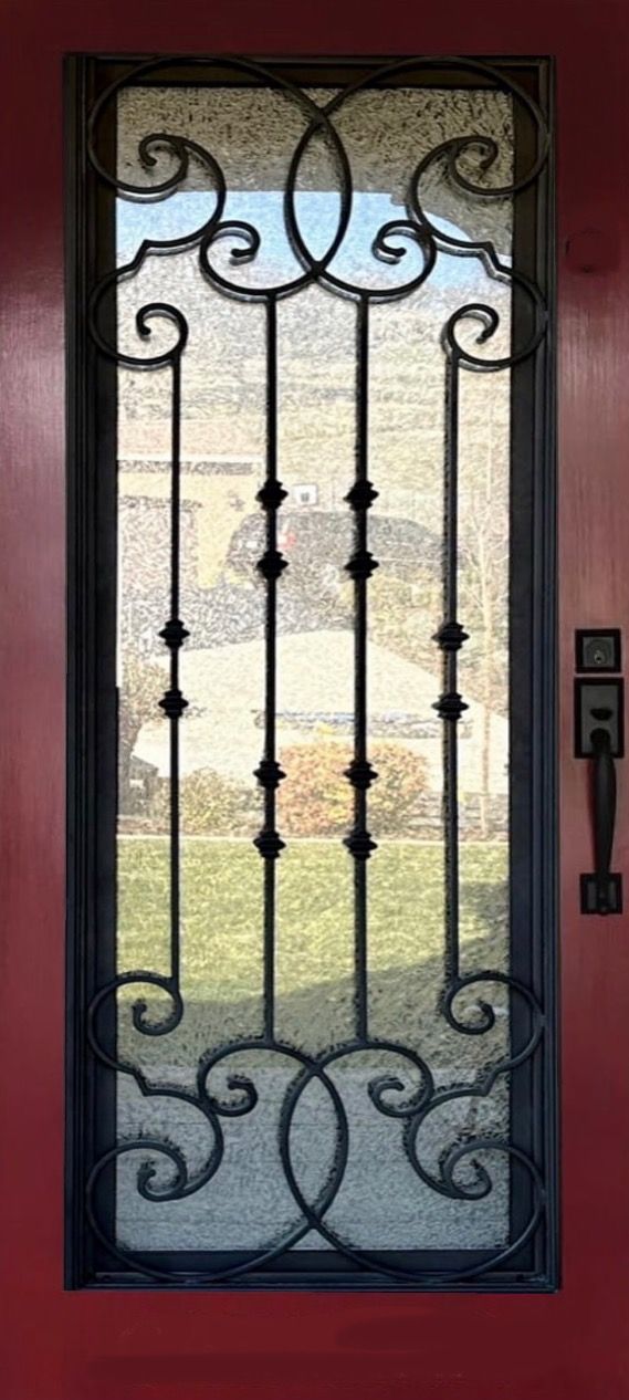 A red door with a wrought iron design on it.