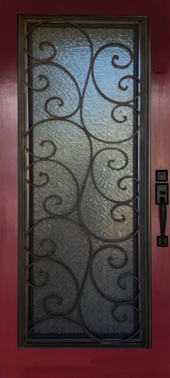 A red door with a wrought iron design on it.