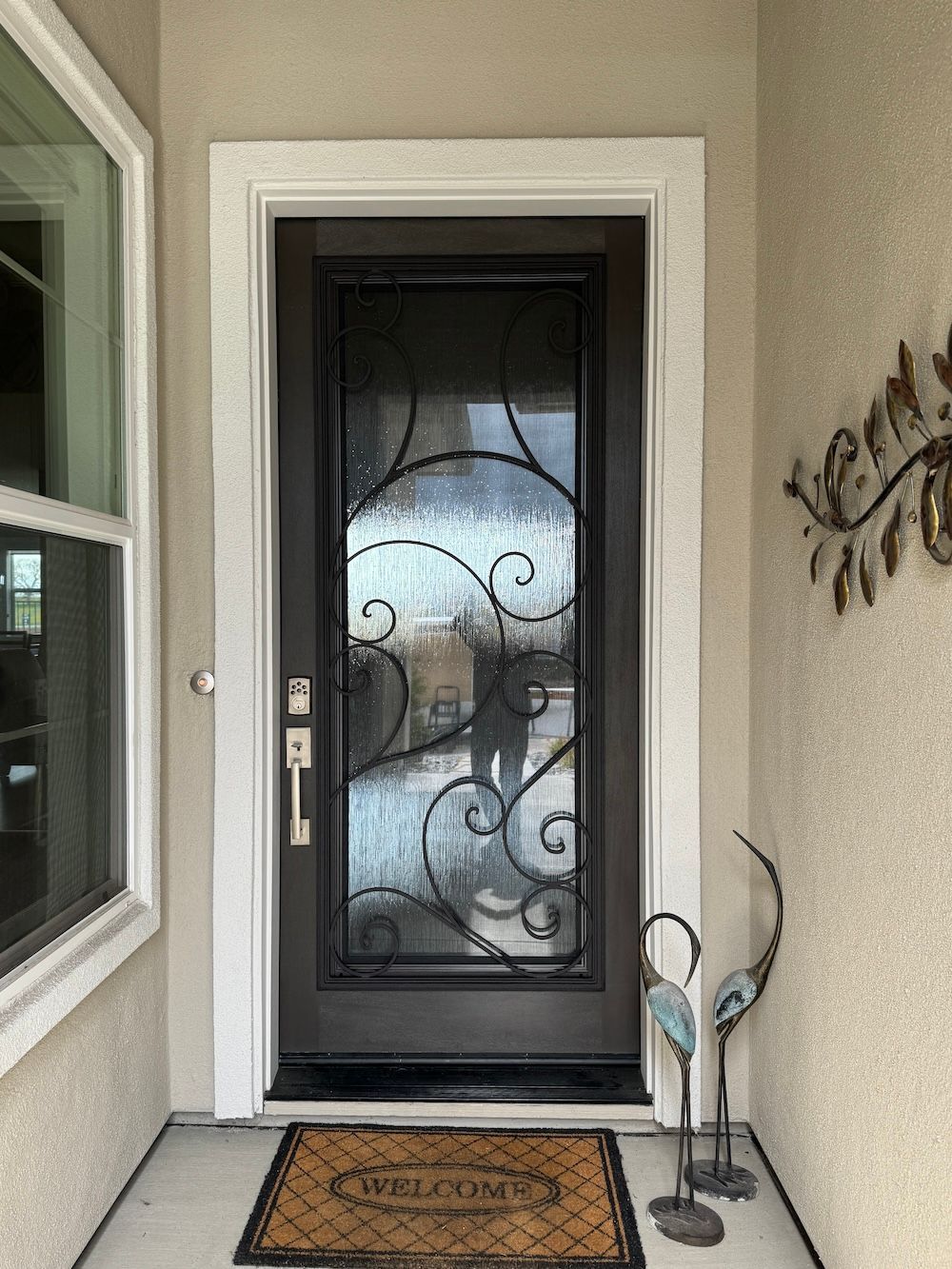 CLICK to see your optons The front door of a house with a wrought iron door and a welcome mat.
