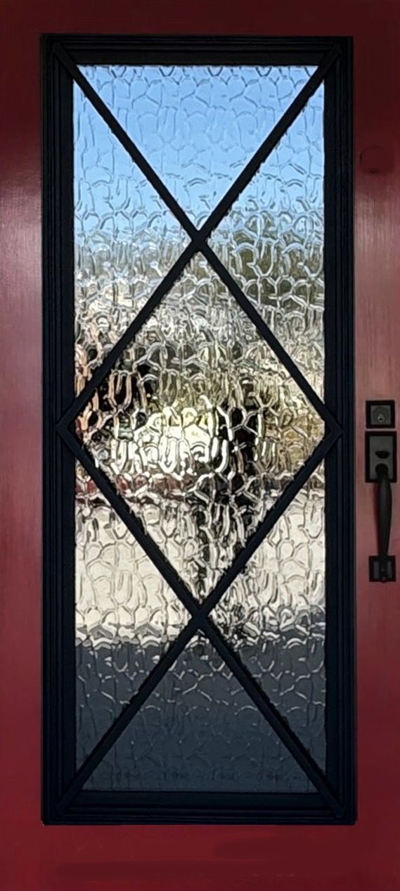 A door with a stained glass window and a black frame.