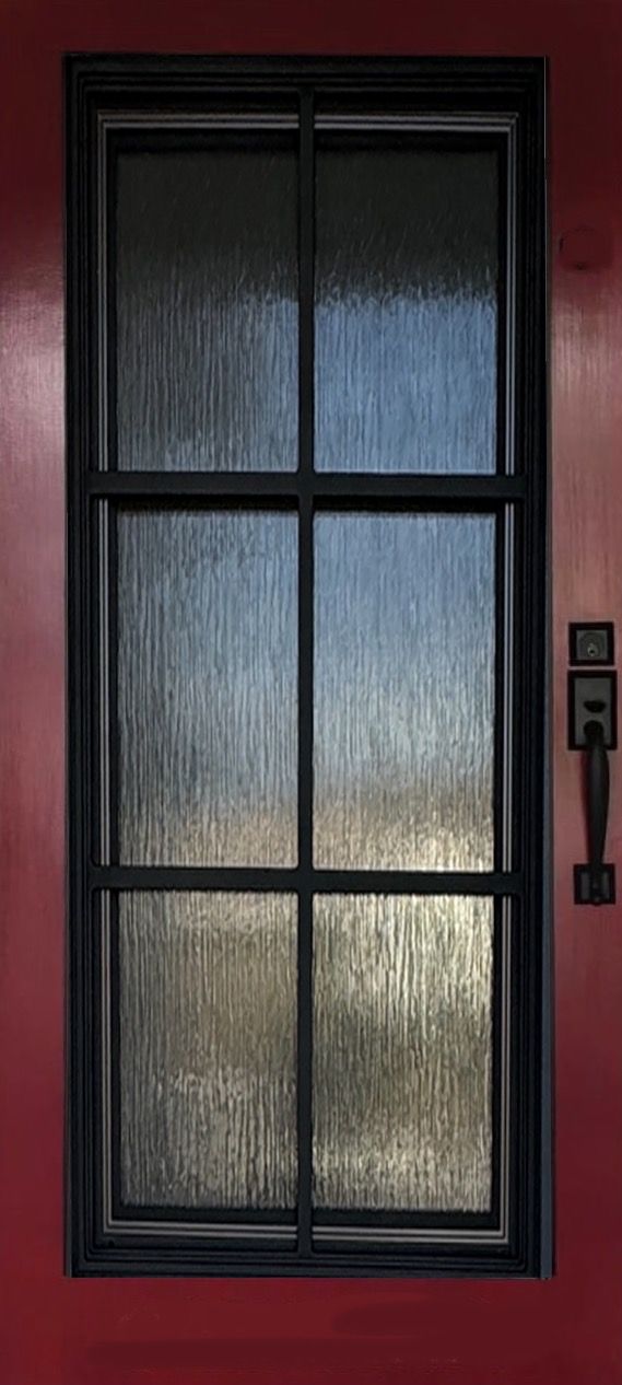 A close up of a window on a red door.