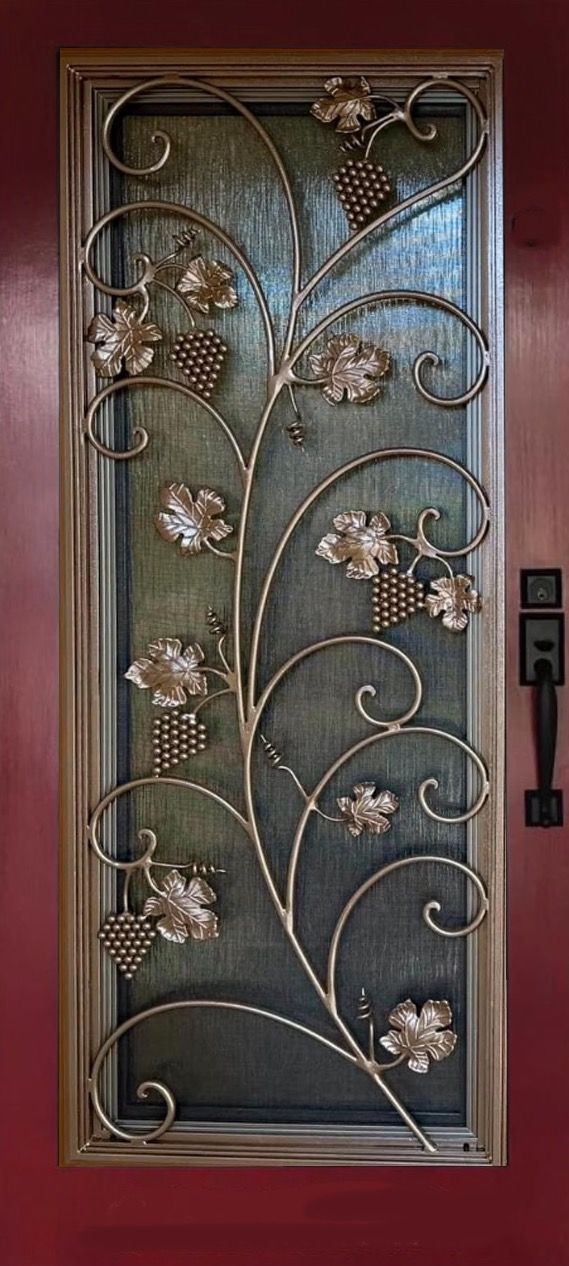 A wrought iron door with flowers and grapes on it.
