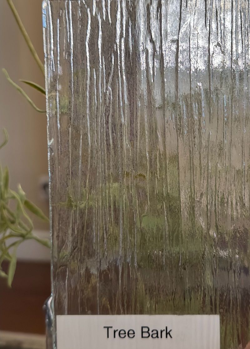 A close up of a tree bark glass with a plant in the background.