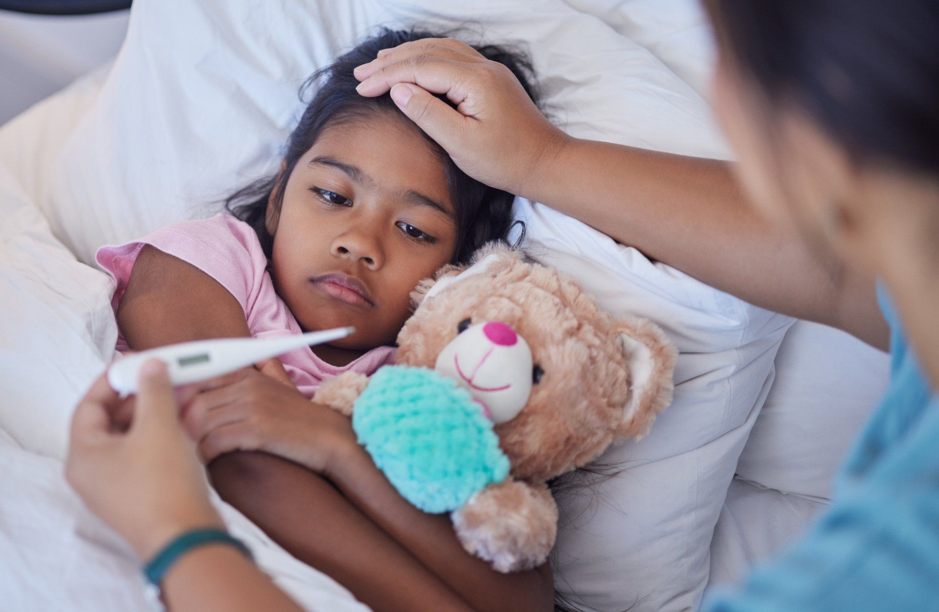 mom checks young daughter's fever