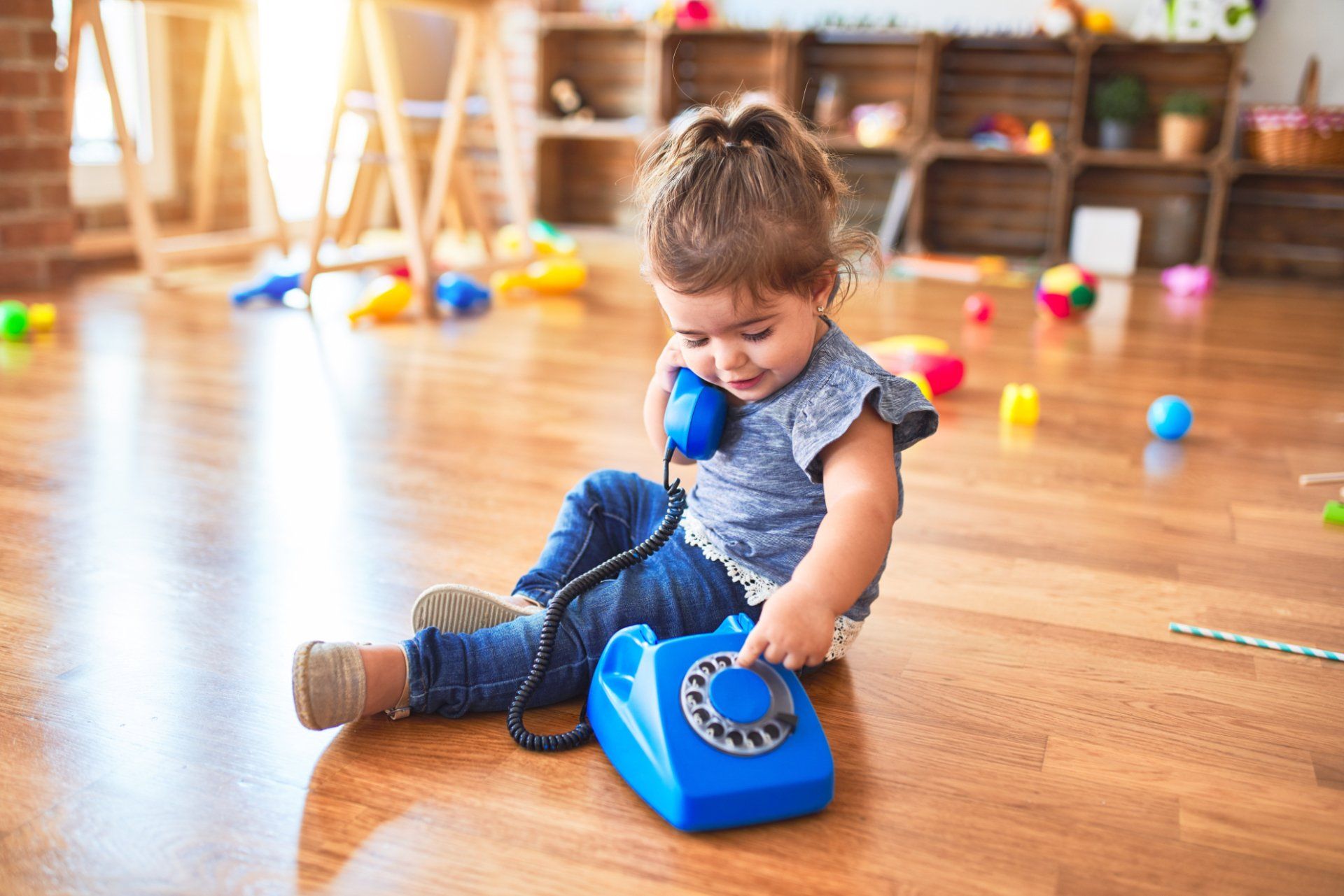 toddler girl using toy telephone
