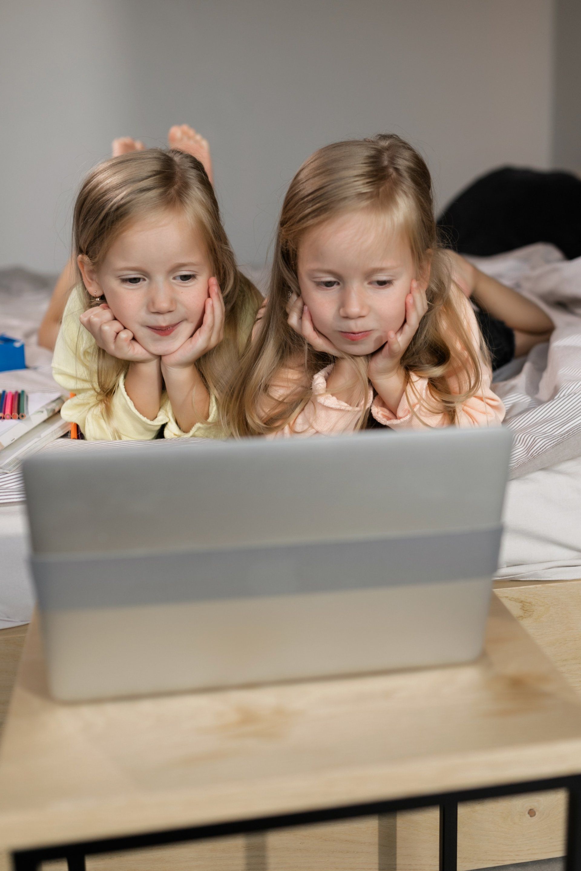 blonde twin girls looking at laptop