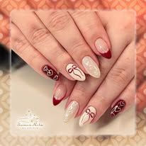 Hands with maroon and nude floral nail art on a soft pink background