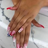 Hands with long pink and white ombré manicured nails on a marble surface