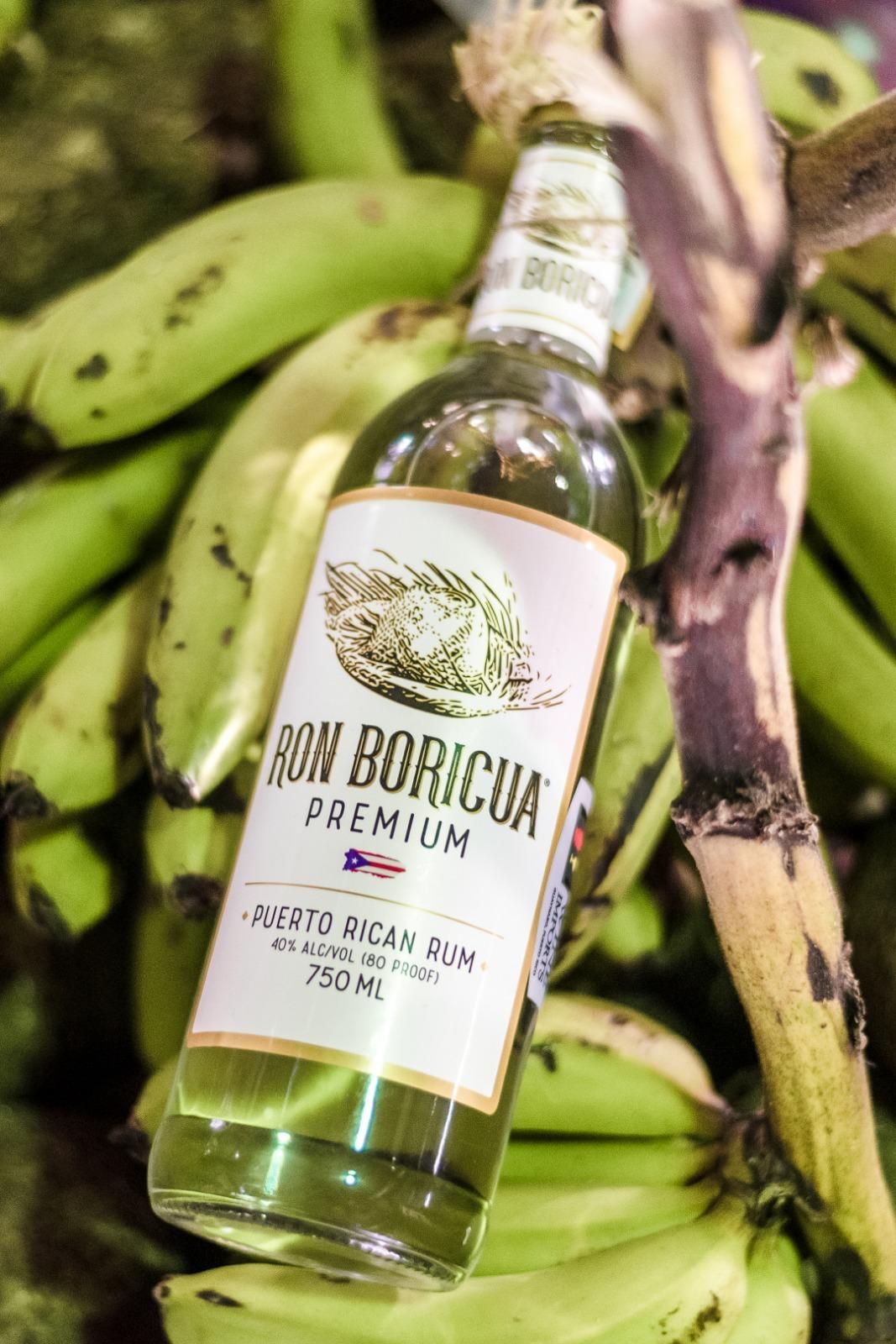 A woman is holding a bottle of Ron Boricua Premium.