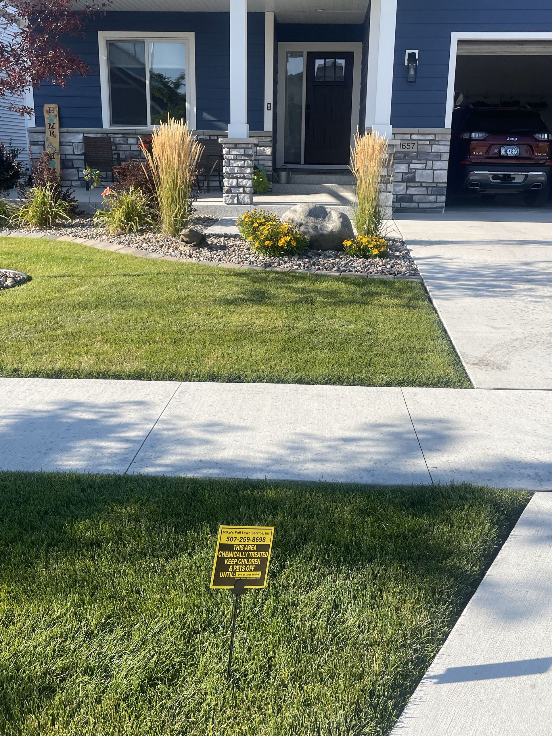 A house with a lawn and a sign in front of it.