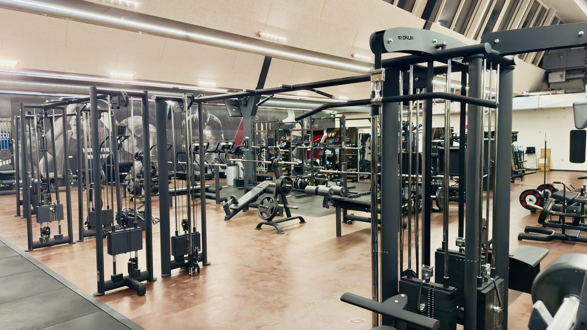Et stort fitnesscenter fyldt med masser af træningsudstyr.
