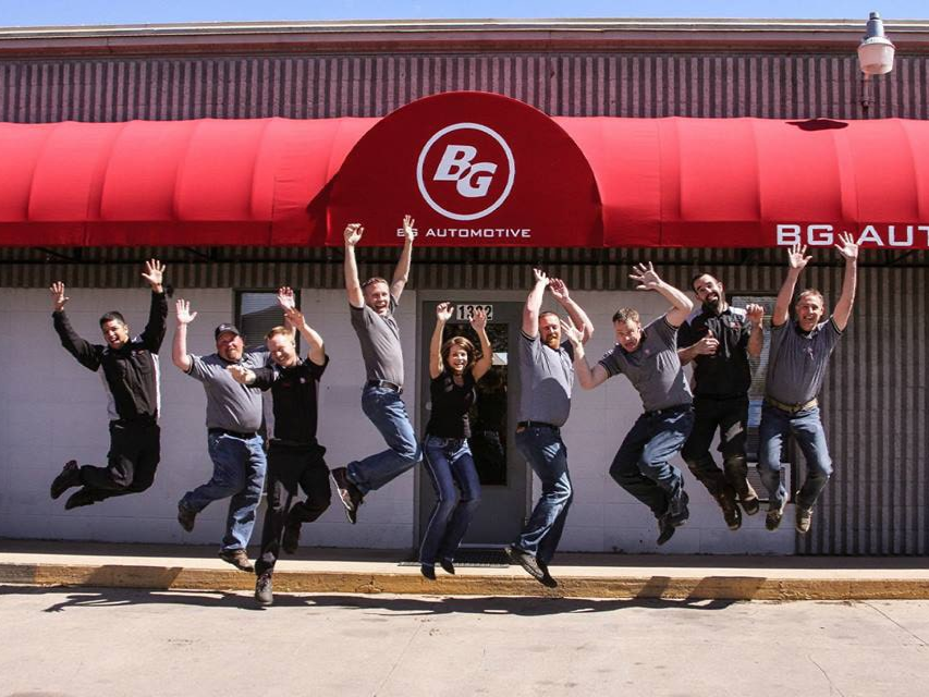 image of an auto repair shop client team jumping in the air