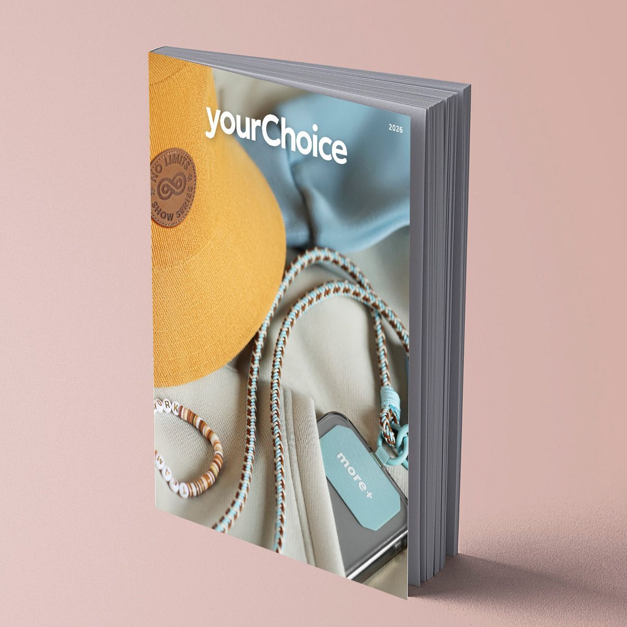 Un catalogue avec une couverture blanche, sur un fond rose clair.