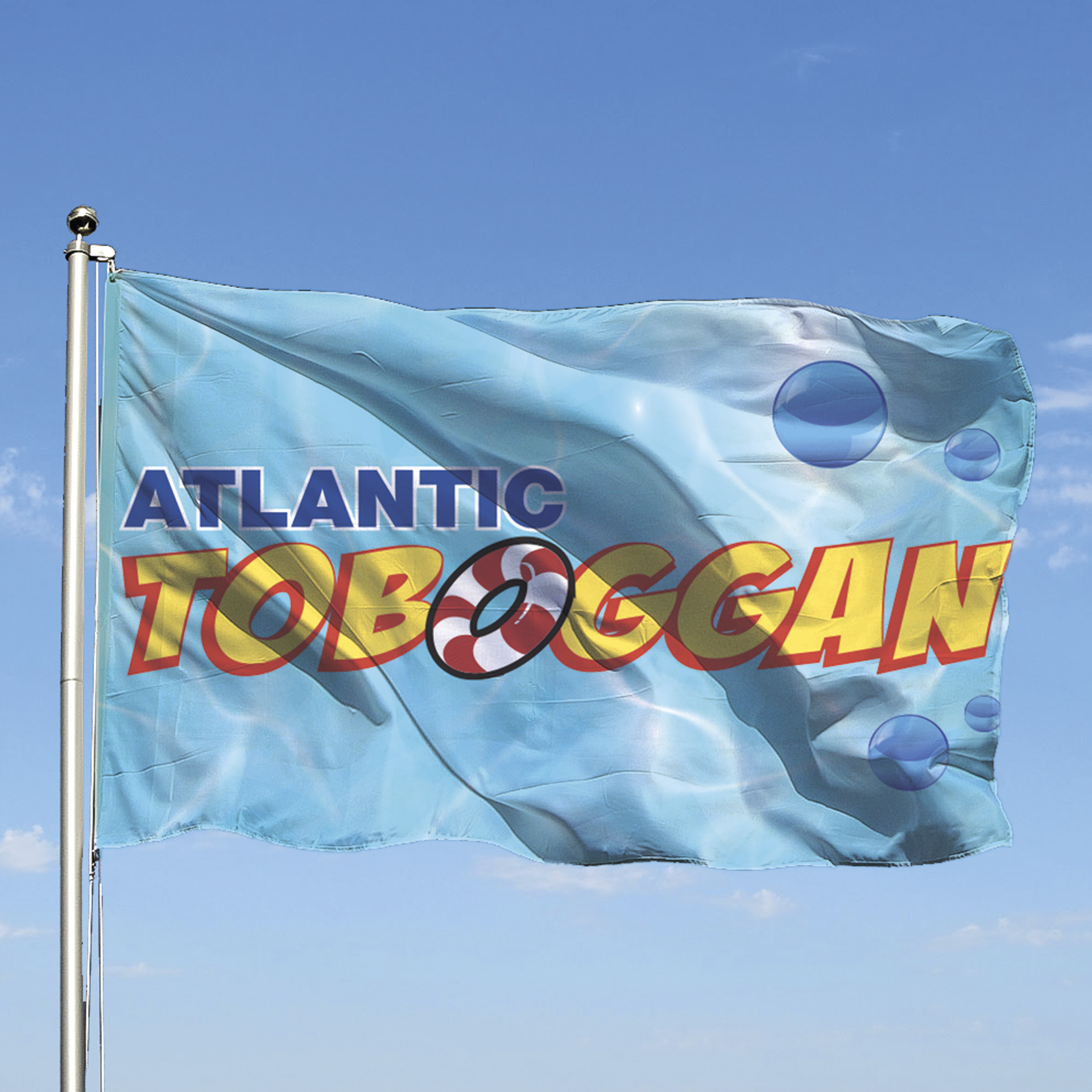 Drapeau du parc « Atlantic Toboggan » flottant au vent. Le drapeau arbore le logo et un motif sur le thème de l'eau.
