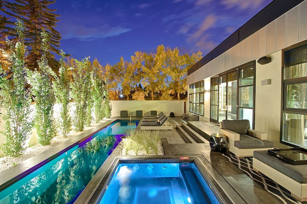 large swimming pool in the backyard of a house.