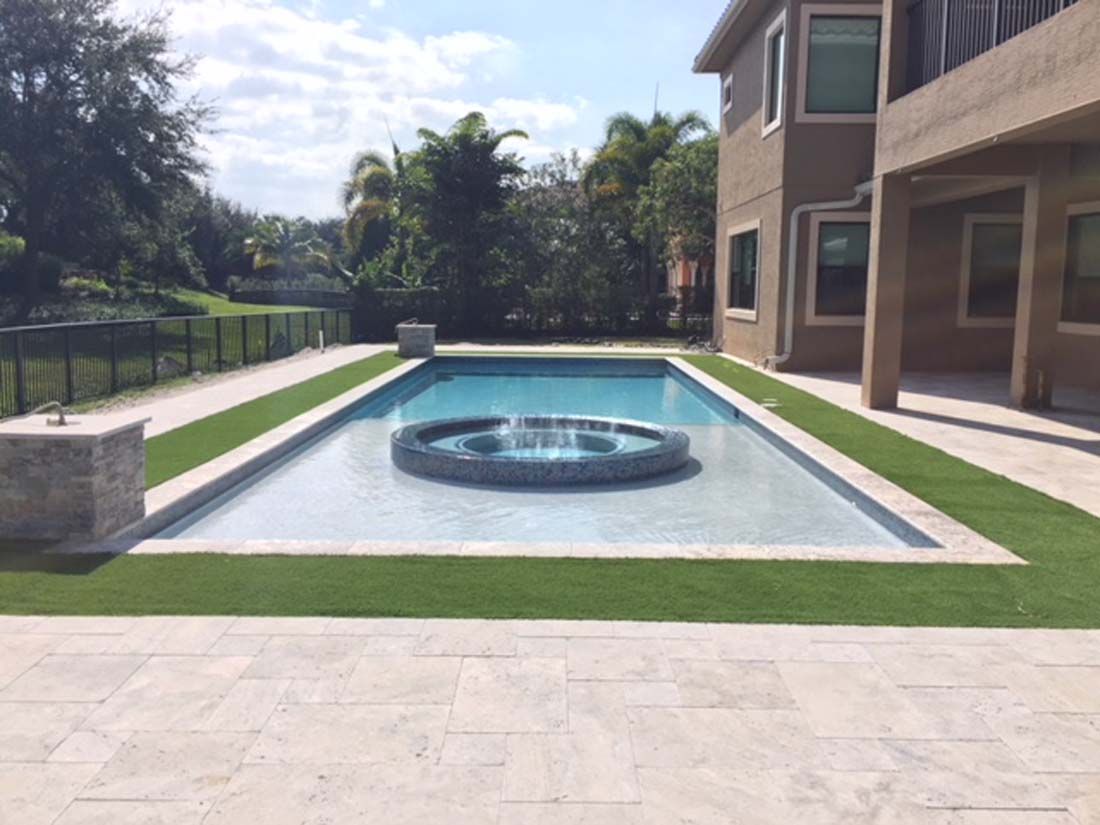 A large swimming pool with a fountain in the middle