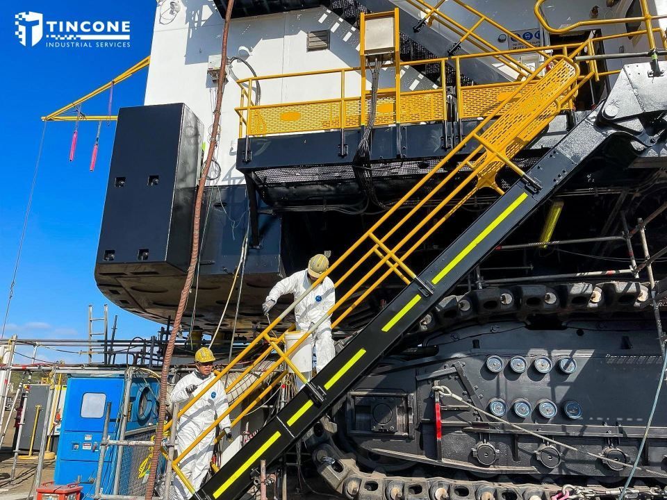 Workers in White Suits and Hard Hats on a Black and Yellow Staircase Attached to Machinery — Tincone Pty Ltd in Paget, QLD