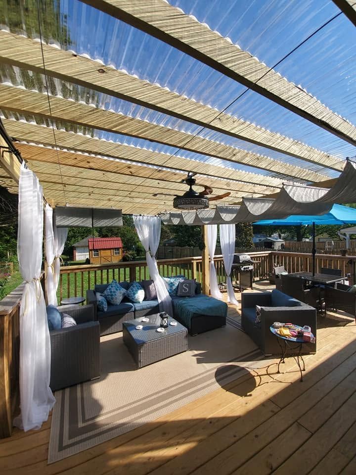 Outdoor patio lounge with teal seating, striped canopy, and string lights on a wooden deck