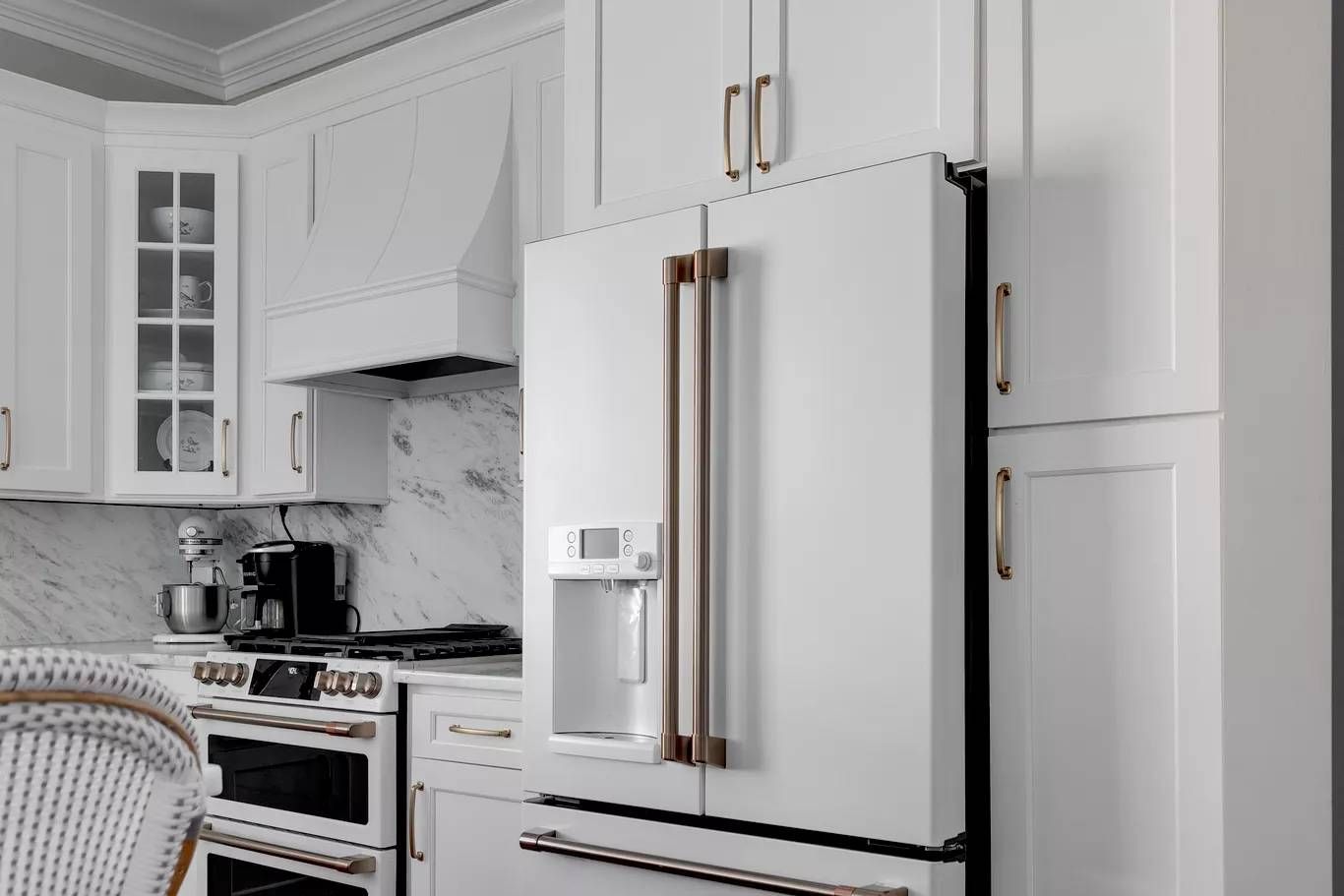 Modern open-plan kitchen with black cabinets, white island, and pendant lights, viewed into a dining area