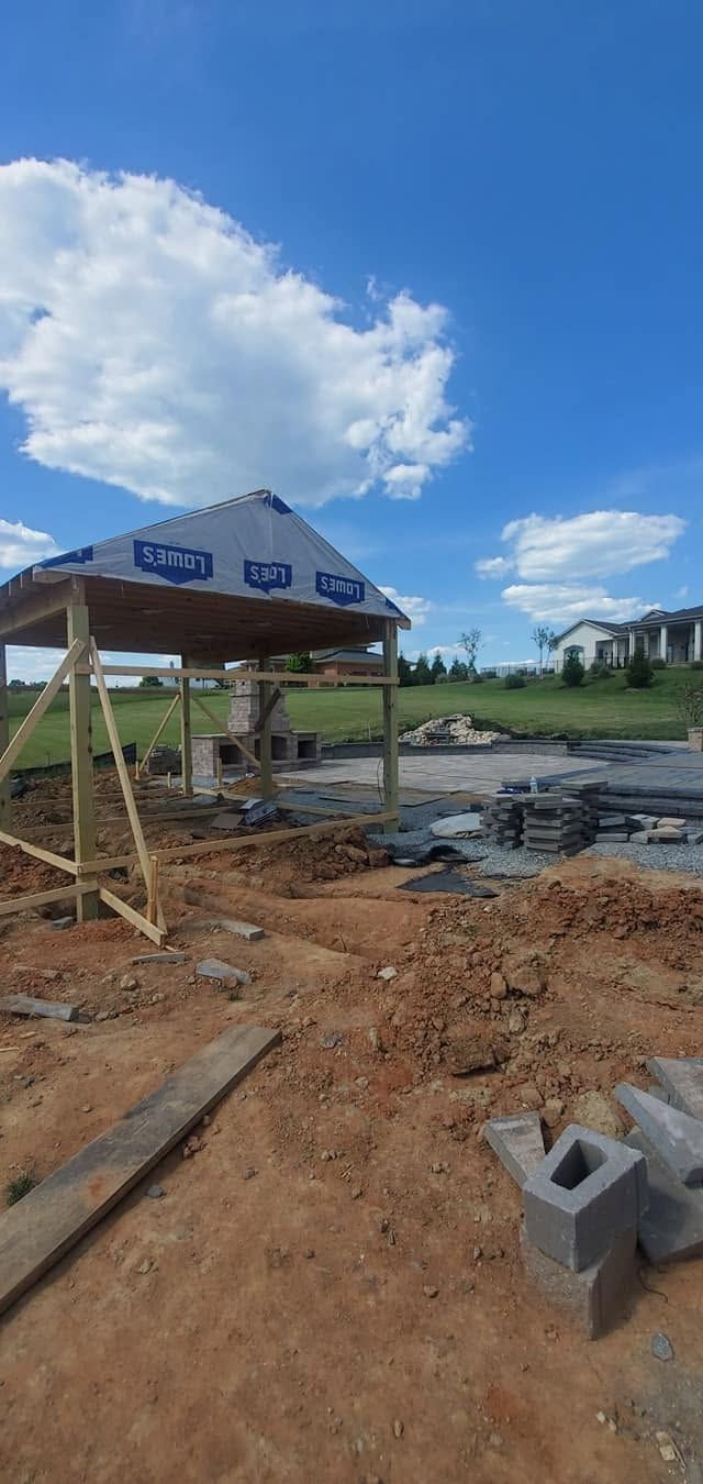 Construction site with a partially built roof, scattered materials, and a blue sky with clouds