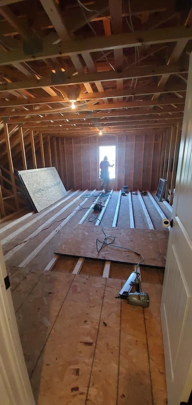 Damaged room with torn-up floorboards and exposed framing, light coming through the far doorway