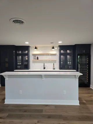 Bright bathroom with a white soaking tub, glass shower, dark wood vanities, and a blue wall print.
