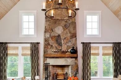 Bright living room with a stone fireplace, chandelier, and two windows with patterned curtains