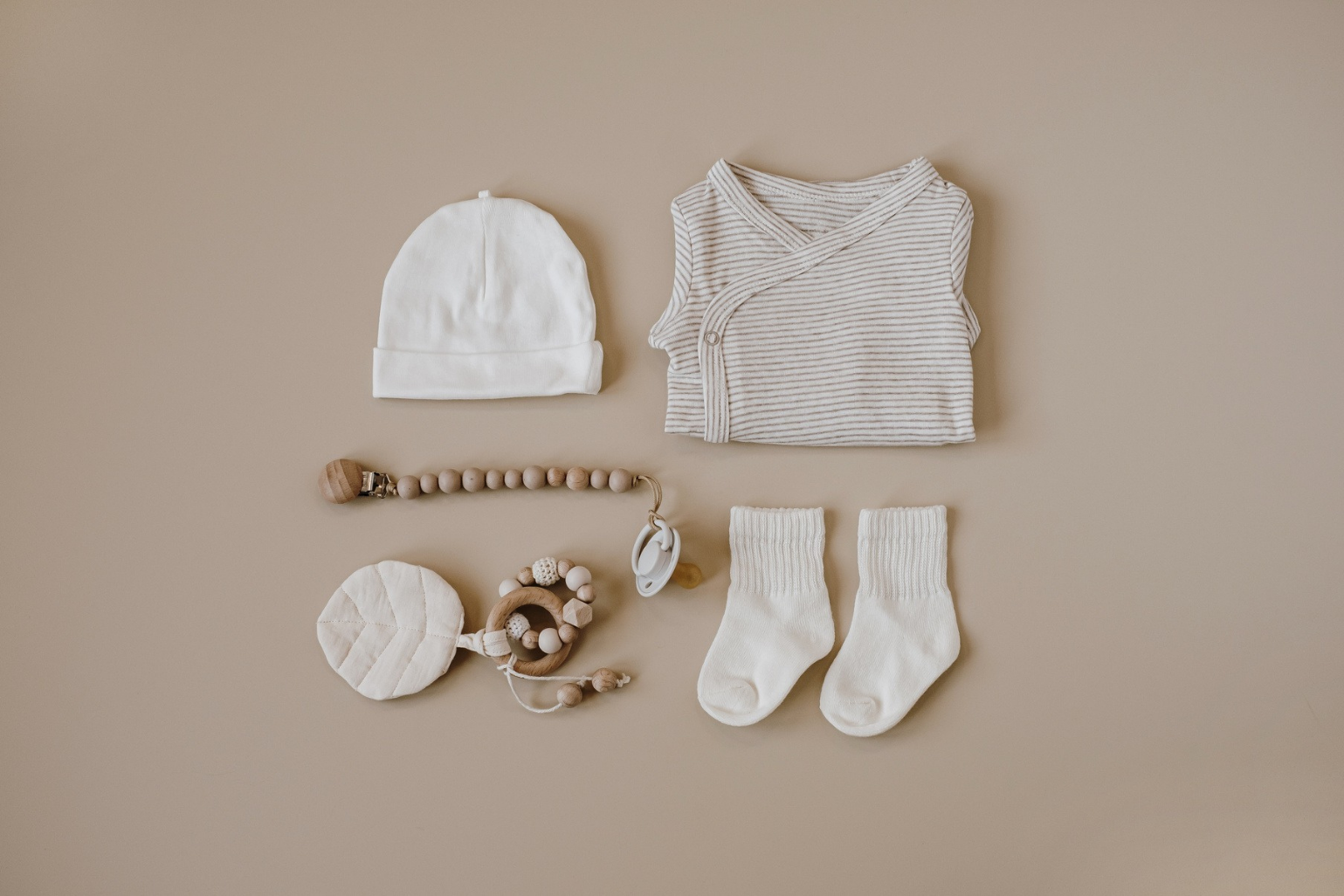 Des vêtements et des accessoires pour bébé sont disposés sur une table.