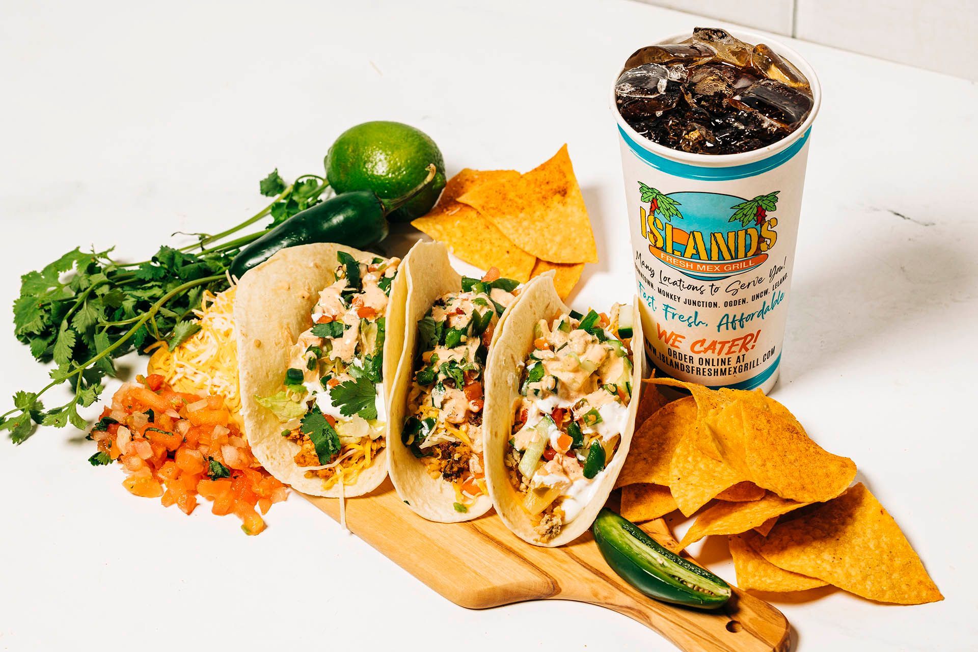a tray of tacos chips and a drink from island 's