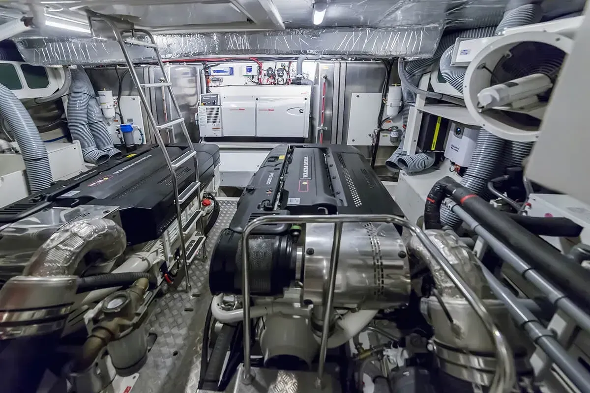 Industrial machinery room with large metal ducts, pipes, and insulated equipment under bright overhead lighting