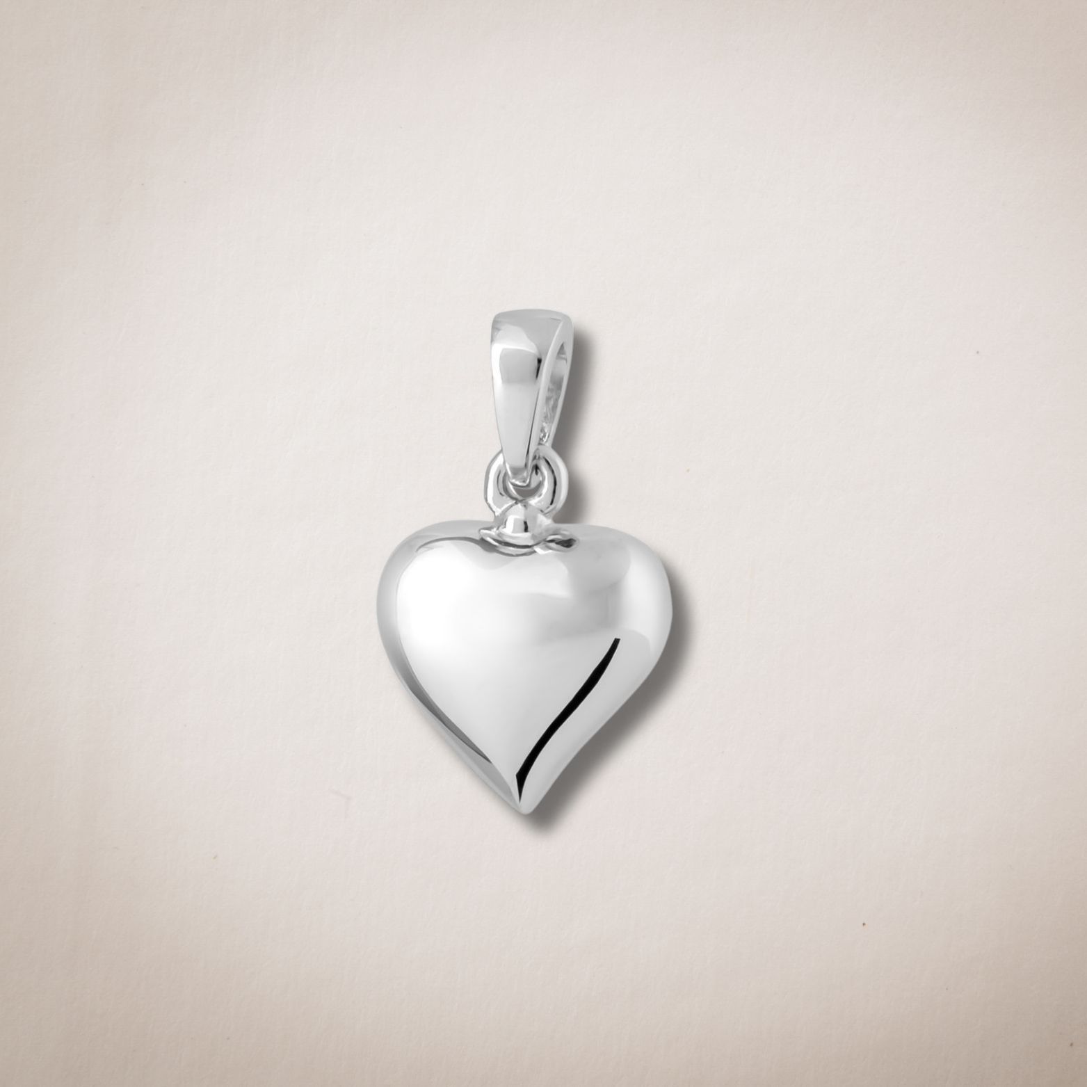 Een klein zilveren hartvormig hangertje aan een ketting