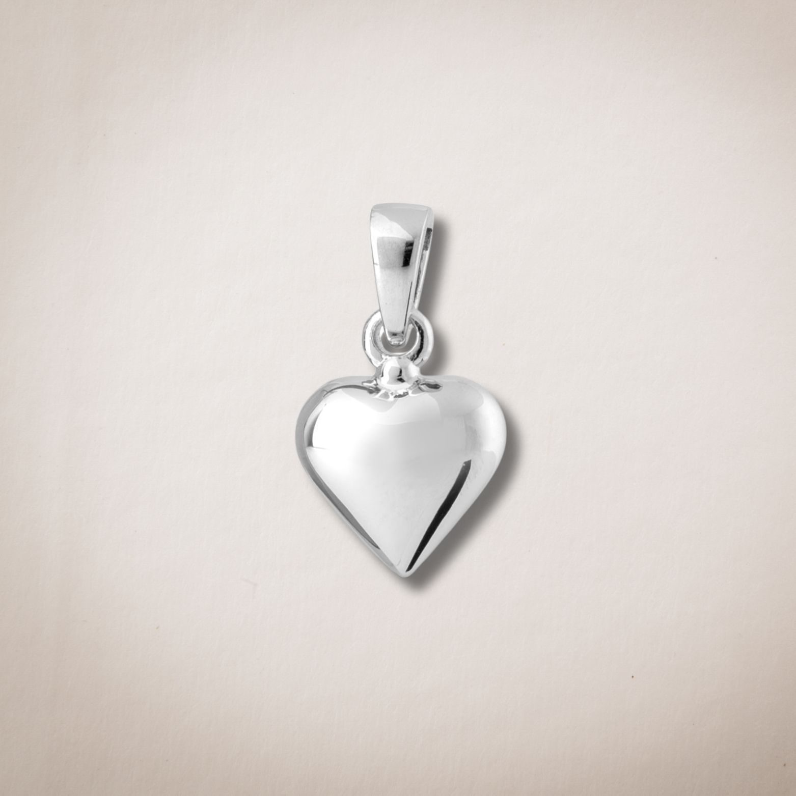 Een klein zilveren hartvormig hangertje aan een ketting