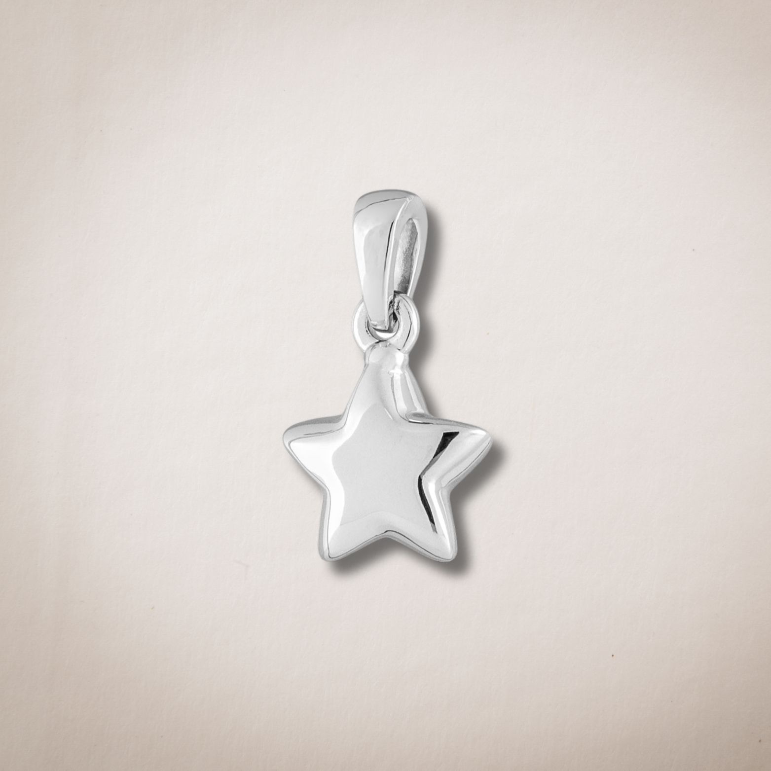 Een klein zilveren stervormig hangertje aan een ketting