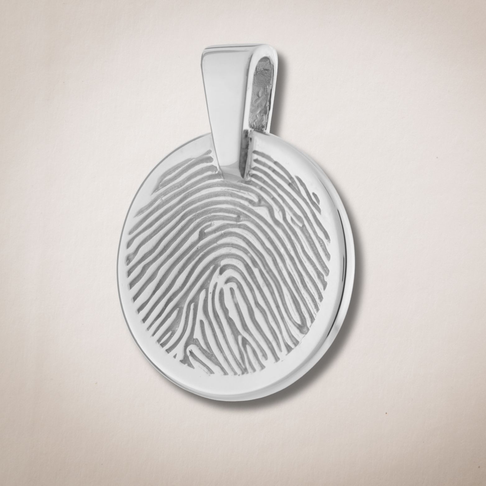 Een zilveren hanger met een vingerafdruk erop