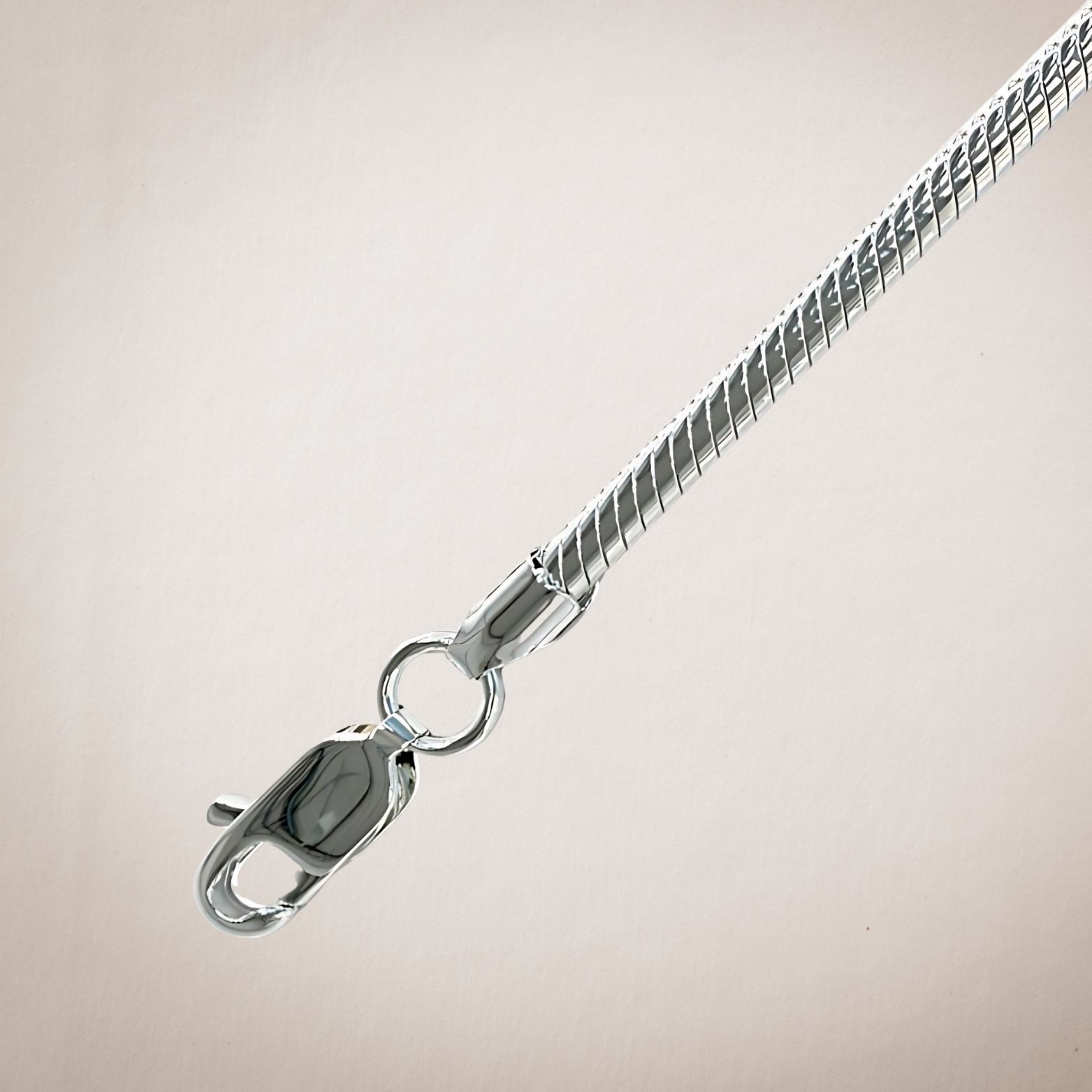 Een close-up van een zilveren ketting met een sluiting op een witte achtergrond.