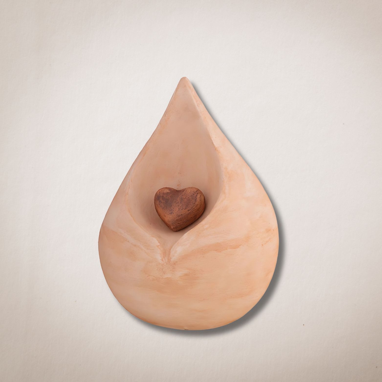 Een keramische traan met daarin een houten hart