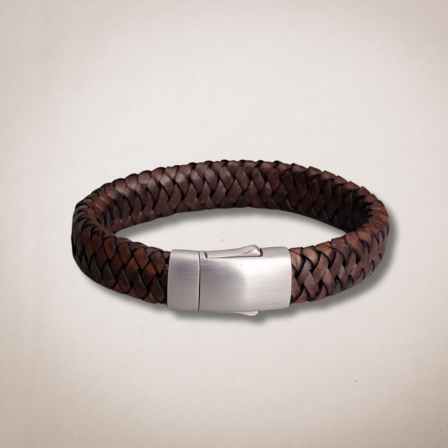 Een bruine gevlochten leren armband met een zilveren sluiting