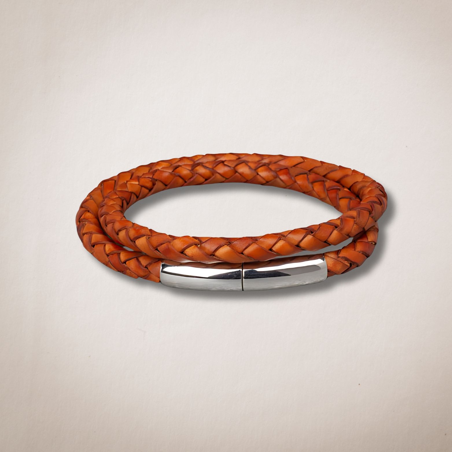 Een bruine gevlochten leren armband met een zilveren sluiting